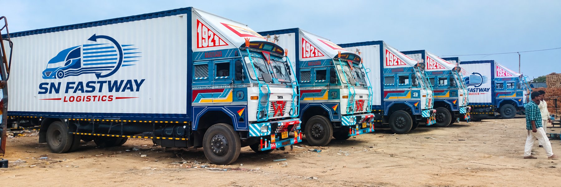 A line of SN Fastway Logistics container trucks parked at the Haryana yard